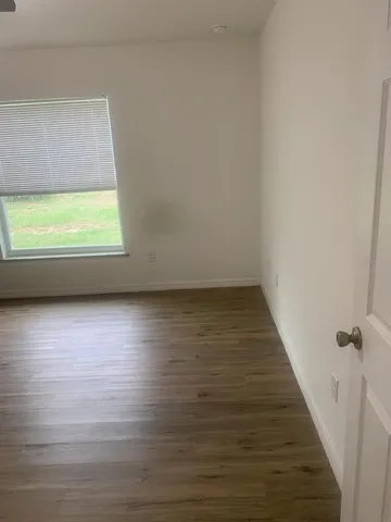 a view of room with window and wooden floor