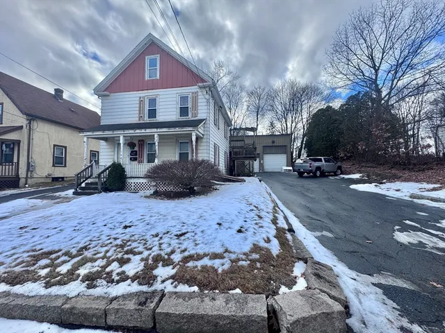 a front view of a house with a yard covered in snow
