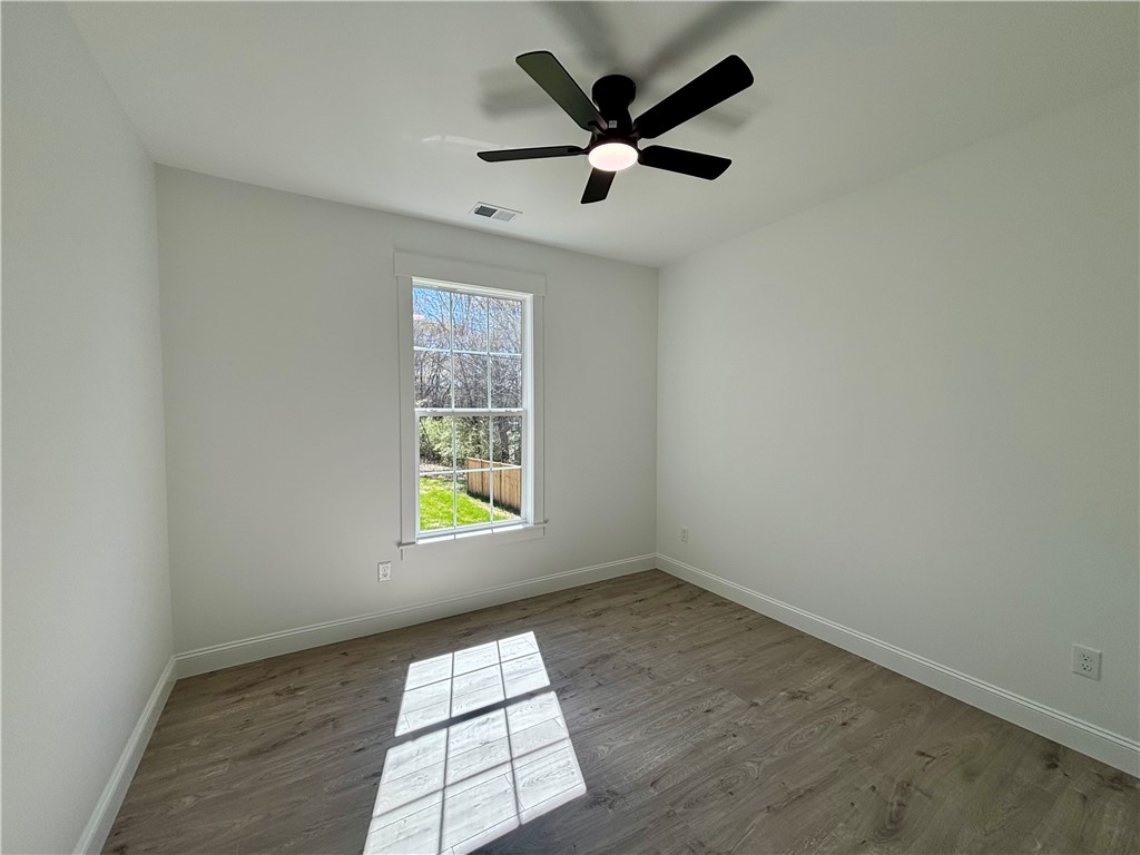 26 B Fisher Jenkins Road Anderson, SC 29625 - Photo 14 of 24 Sunlight fills this bright room, highlighting its beautiful flooring and spacious layout.