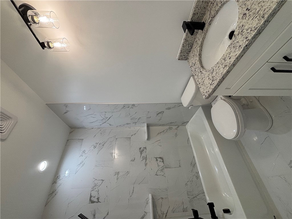 26 B Fisher Jenkins Road Anderson, SC 29625 - Photo 15 of 24 This newly updated bathroom features elegant marble-look tiling and modern fixtures.