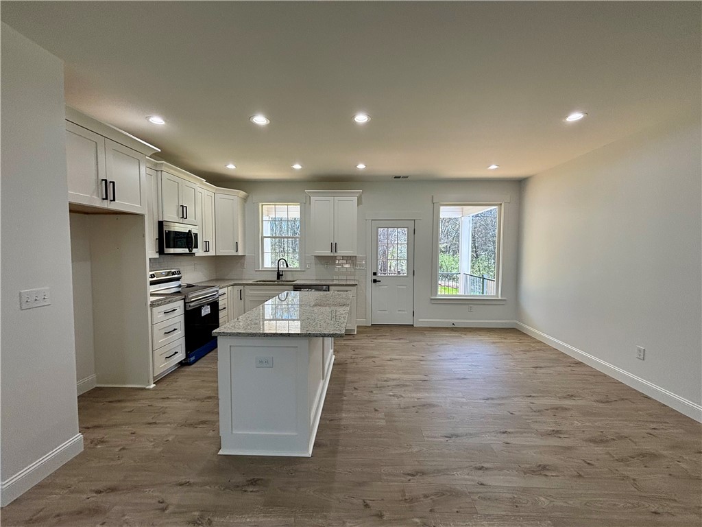 26 B Fisher Jenkins Road Anderson, SC 29625 - Photo 9 of 24 This bright, open kitchen boasts an island with ample counter space and modern appliances.
