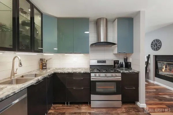 a kitchen with granite countertop a stove top oven cabinetry and refrigerator