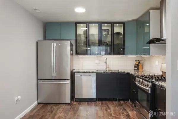 a kitchen with granite countertop a refrigerator and a stove top oven