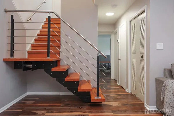 a view of entryway bedroom and hall with wooden floor