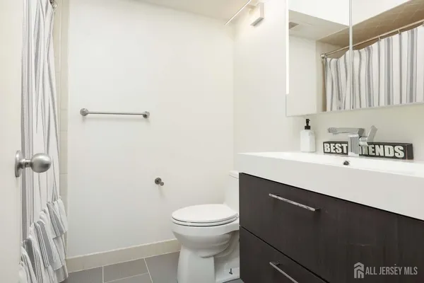 a bathroom with a sink a toilet and a mirror