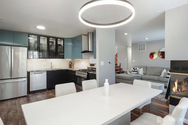 a large kitchen with a large counter top space a sink stainless steel appliances and cabinets