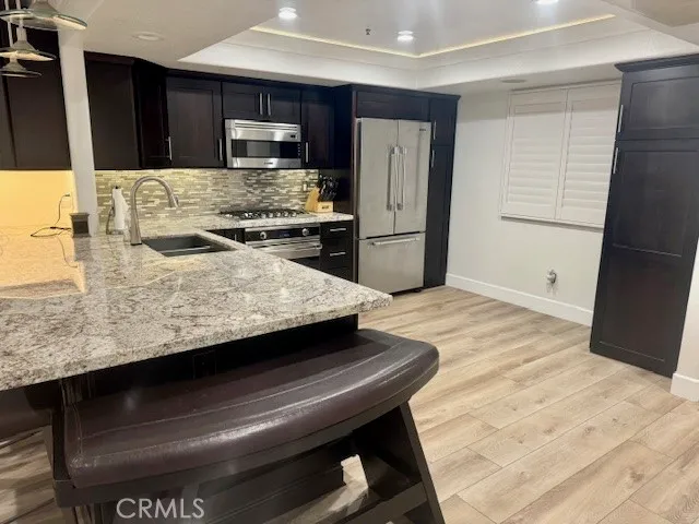 a kitchen with granite countertop wooden cabinets and stainless steel appliances
