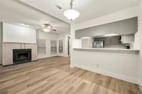a view of a kitchen with a sink and dishwasher with wooden floor