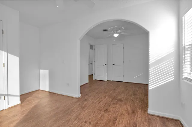 a view of an empty room with wooden floor