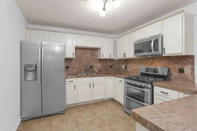 a bathroom with a granite countertop sink toilet a mirror and shower