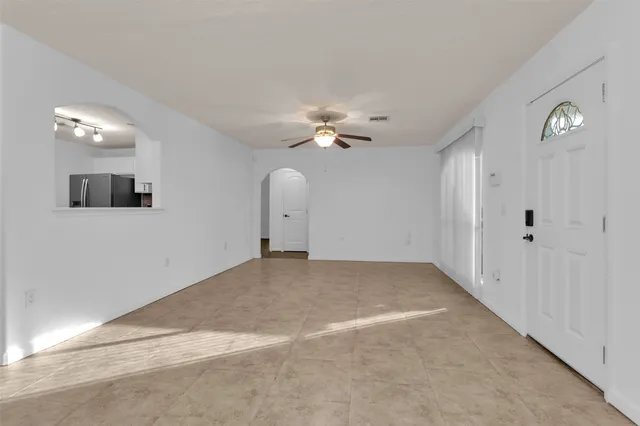 a view of a livingroom with a ceiling fan window and a ceiling fan