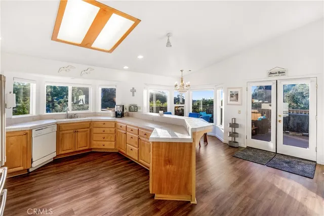 a large white kitchen with wooden floors and wide window