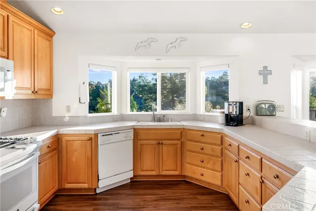 a kitchen with granite countertop white cabinets and white appliances
