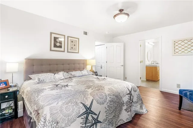 a bedroom with a bed and a wooden floor