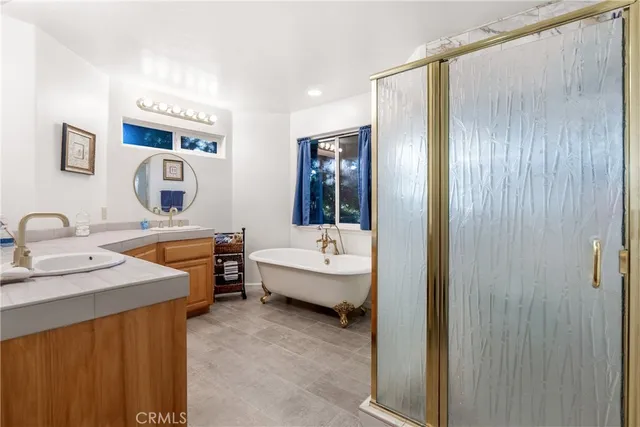 a bathroom with a tub sink and mirror