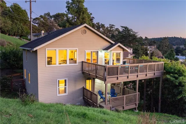 a view of a house with brick walls and a yard with trees