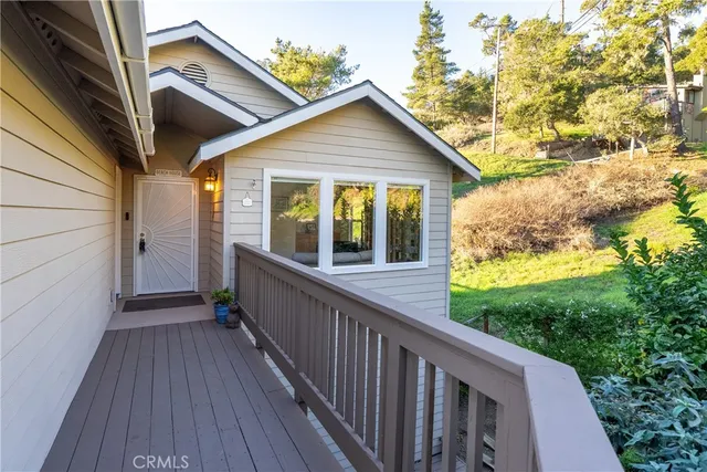 a view of a house with wooden deck and backyard