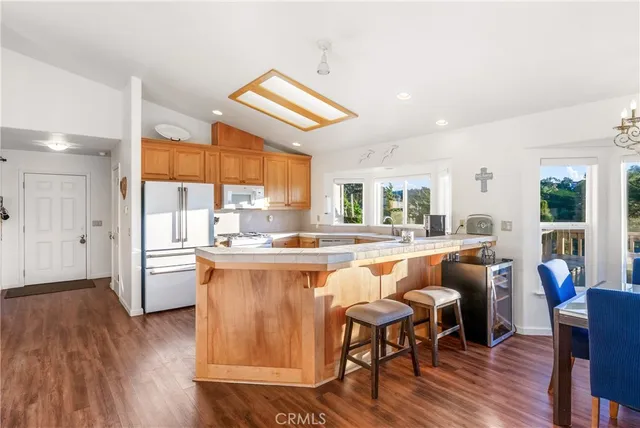a kitchen with a table chairs refrigerator and window