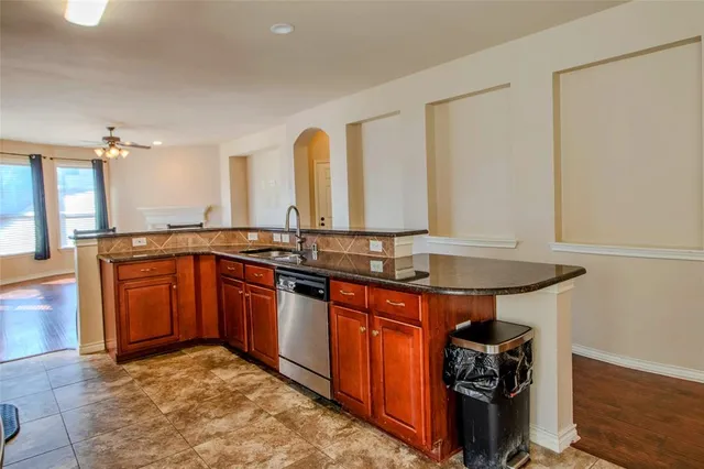 a kitchen with stainless steel appliances granite countertop a refrigerator a stove and a sink with cabinets