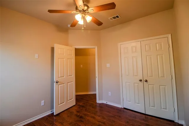 a view of room with window ceiling fan and wooden floor