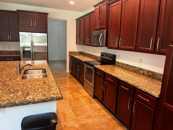 a kitchen with stainless steel appliances granite countertop wooden cabinets a oven and granite counter tops