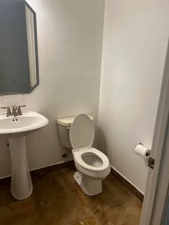 a bathroom with a toilet sink and mirror