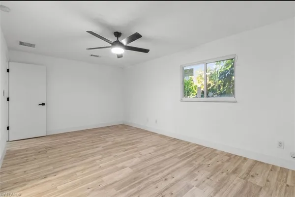 a view of empty room with wooden floor