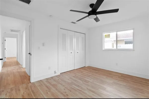 a view of a room with wooden floor and a ceiling fan