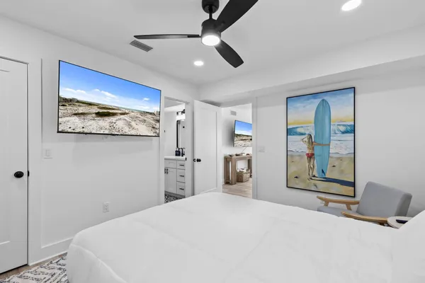 a bedroom with a large bed and a chandelier