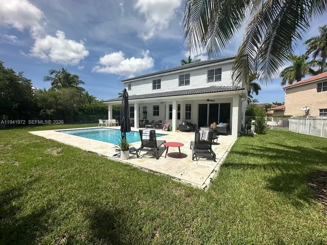 a view of backyard with swimming pool and furniture