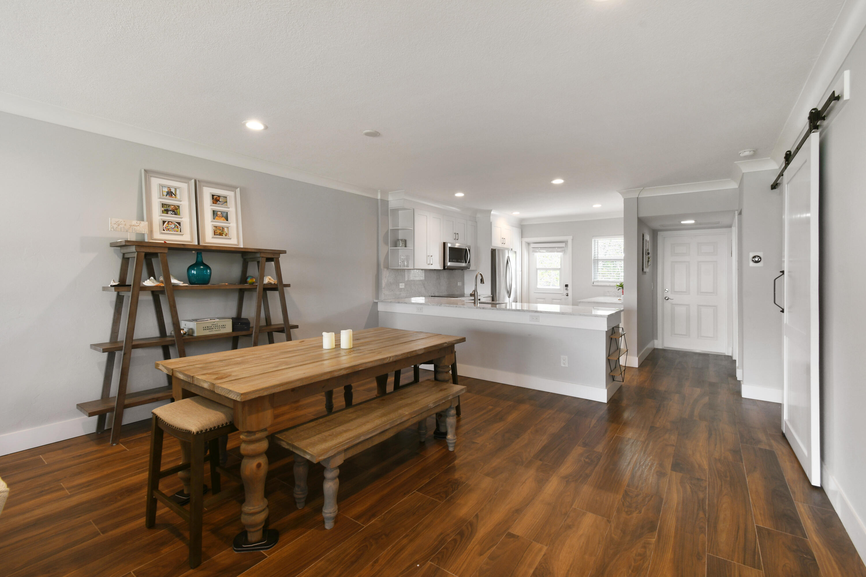 80 Celestial Way, Unit 211 Juno Beach, FL 33408 - Photo 11 of 45 a room with stainless steel appliances wooden floors dining table and chairs