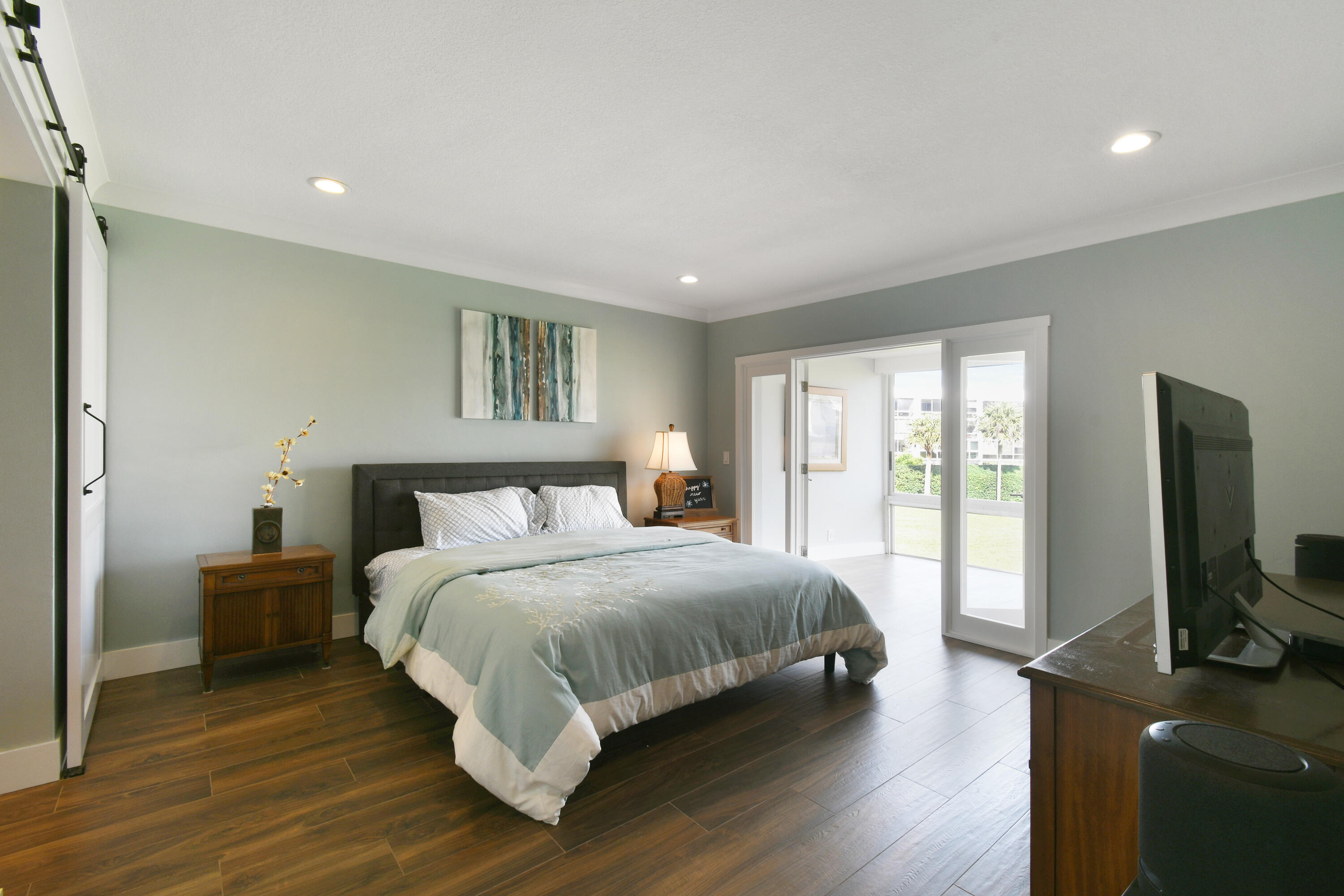 80 Celestial Way, Unit 211 Juno Beach, FL 33408 - Photo 23 of 45 a bedroom with a bed and a flat screen tv