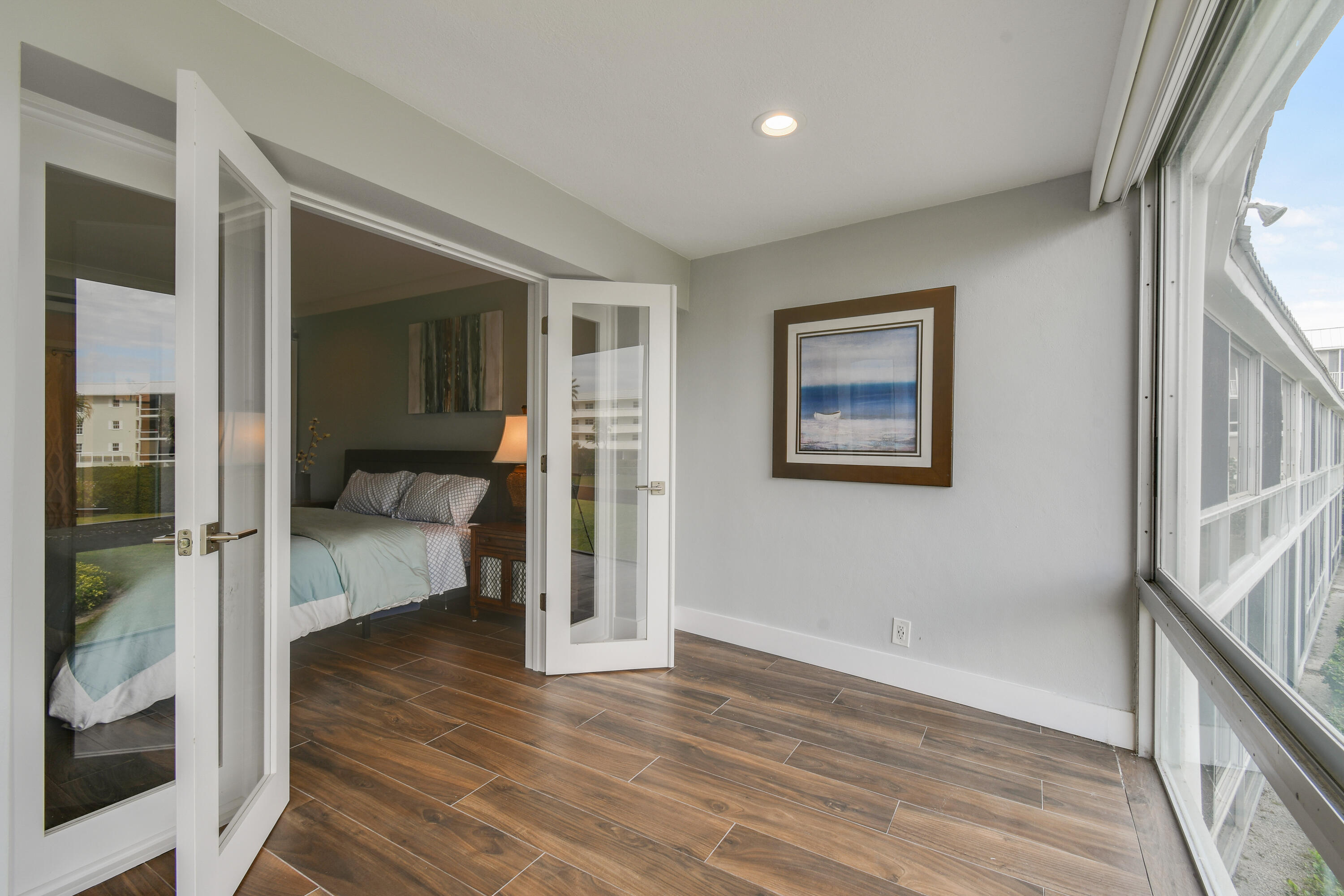 80 Celestial Way, Unit 211 Juno Beach, FL 33408 - Photo 26 of 45 a view of a hallway with wooden floor and a bedroom