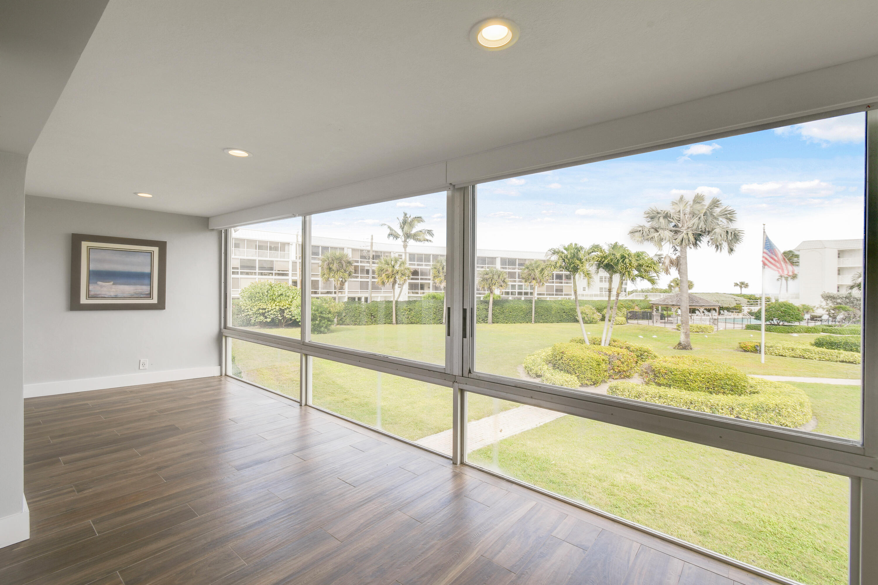 80 Celestial Way, Unit 211 Juno Beach, FL 33408 - Photo 28 of 45 a view of an empty room with wooden floor and a large window