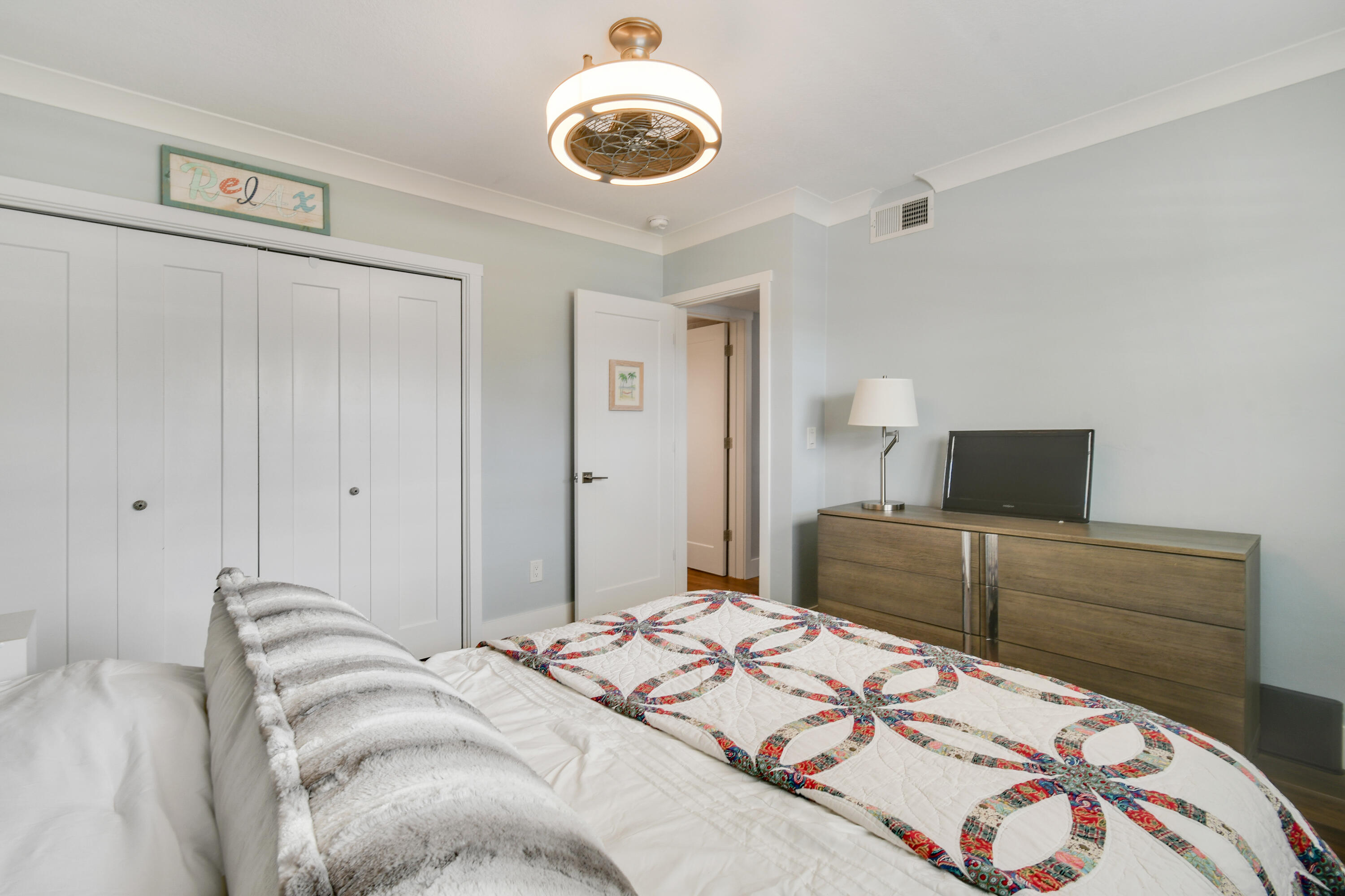 80 Celestial Way, Unit 211 Juno Beach, FL 33408 - Photo 31 of 45 a bedroom with a bed and a chandelier