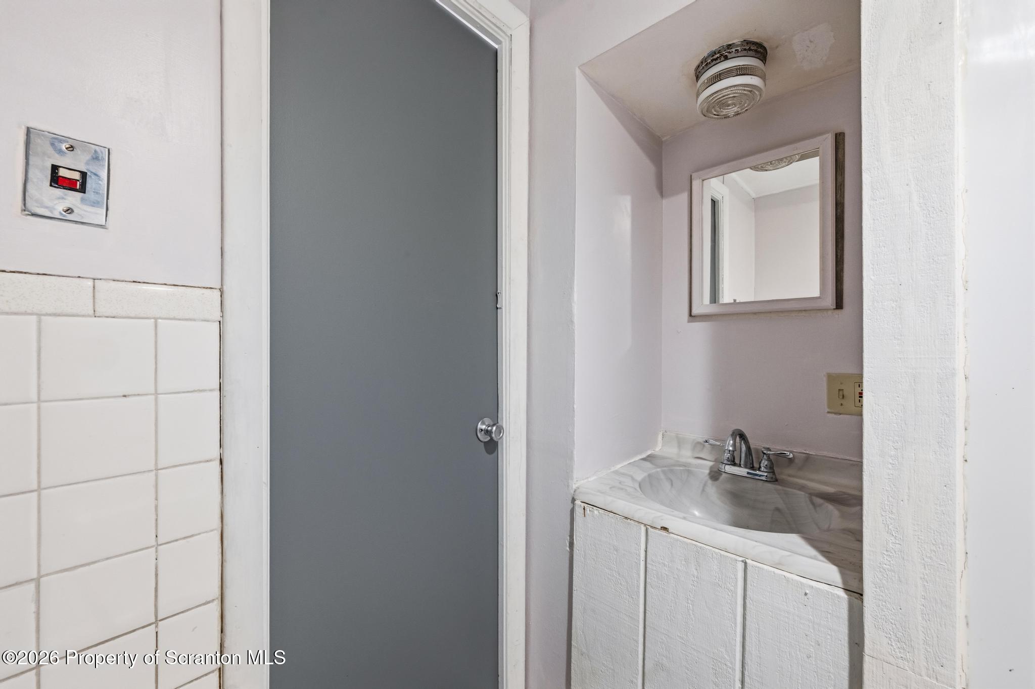 1413 Bulwer Street Scranton, PA 18504 - Photo 12 of 45 a bathroom with a sink a mirror and vanity