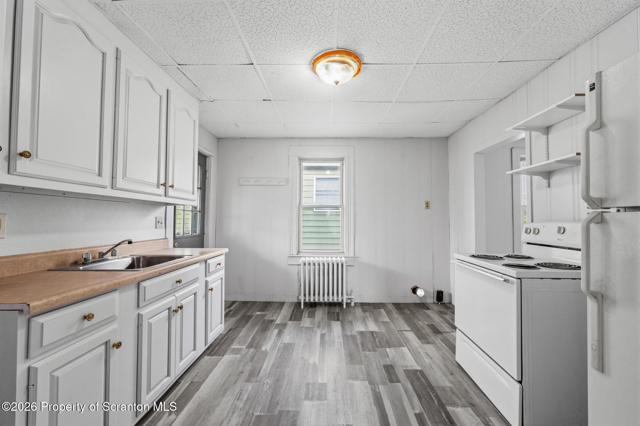 1413 Bulwer Street Scranton, PA 18504 - Photo 24 of 45 a kitchen with cabinets appliances and a wooden floor