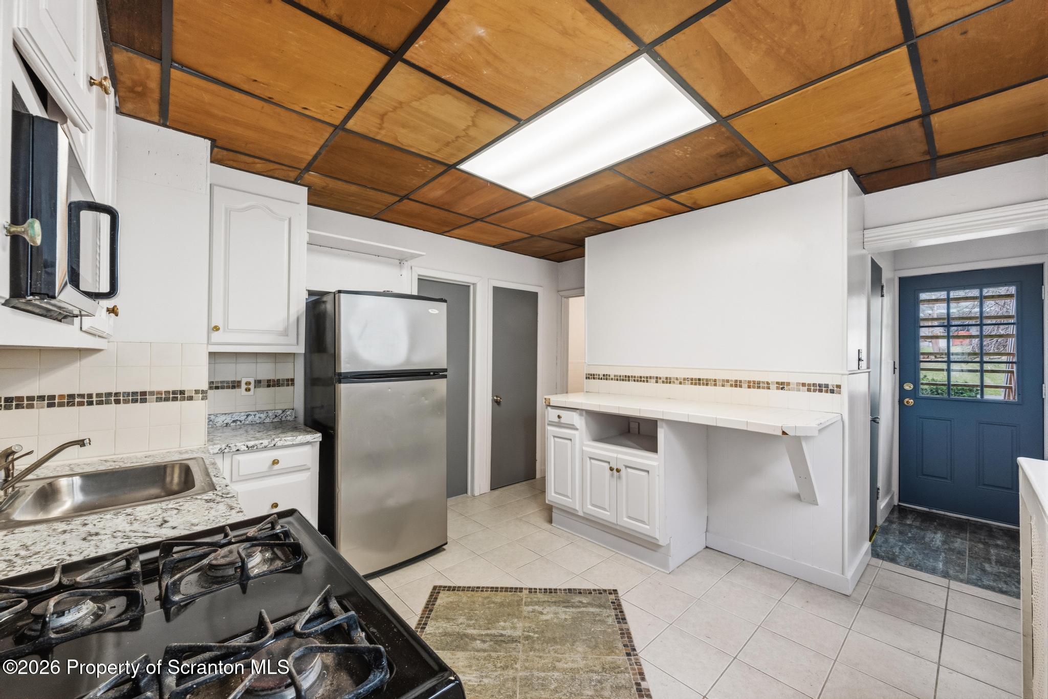 1413 Bulwer Street Scranton, PA 18504 - Photo 3 of 45 a kitchen with stainless steel appliances granite countertop a stove a sink and a refrigerator