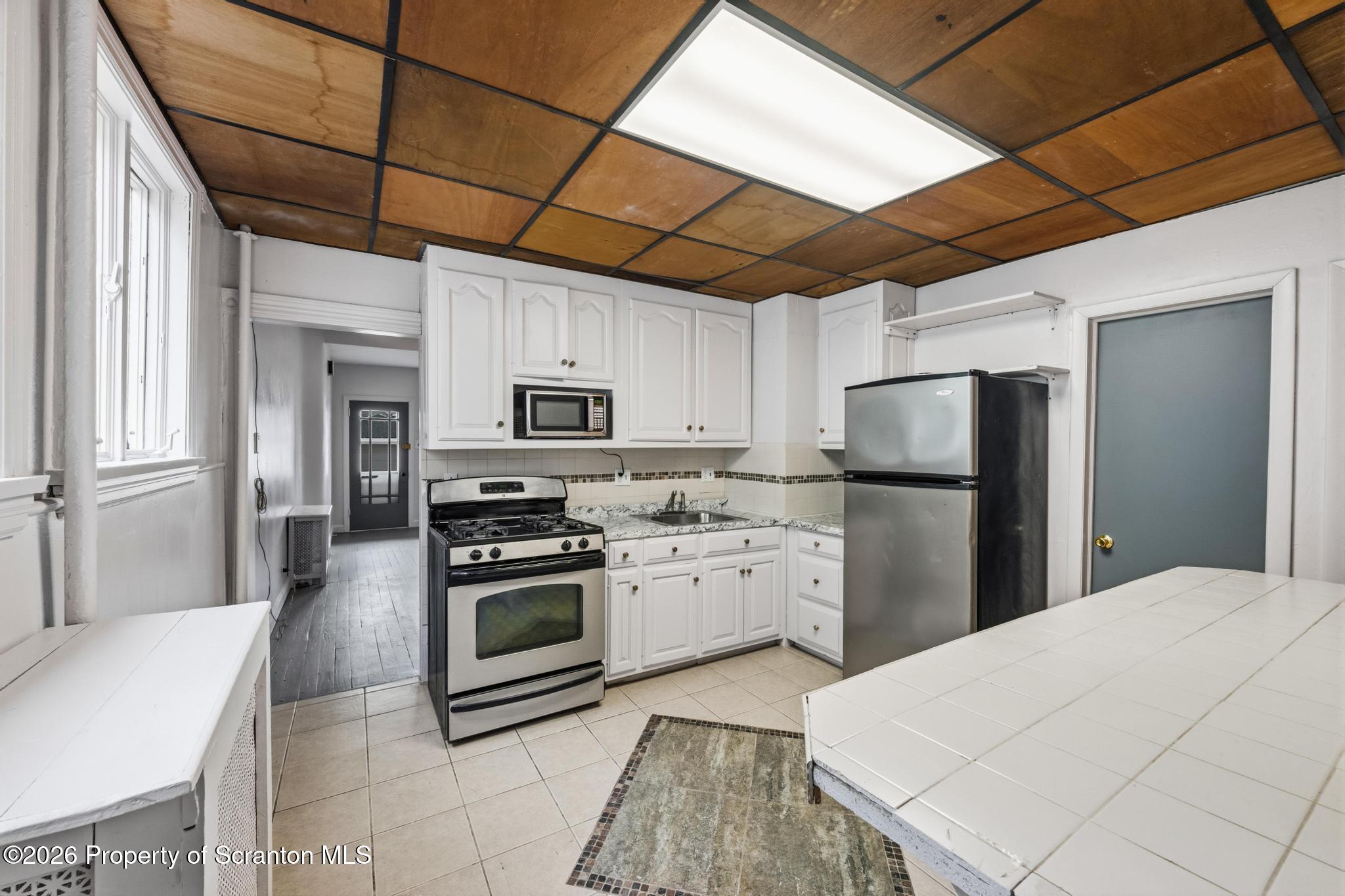 1413 Bulwer Street Scranton, PA 18504 - Photo 4 of 45 a kitchen with refrigerator cabinets and a stove