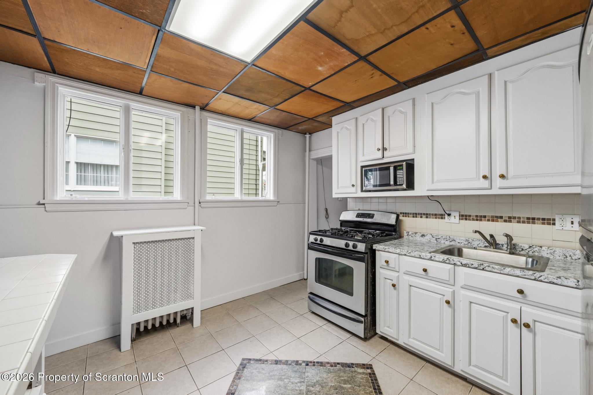 1413 Bulwer Street Scranton, PA 18504 - Photo 5 of 45 a kitchen with stainless steel appliances granite countertop a sink stove and cabinets