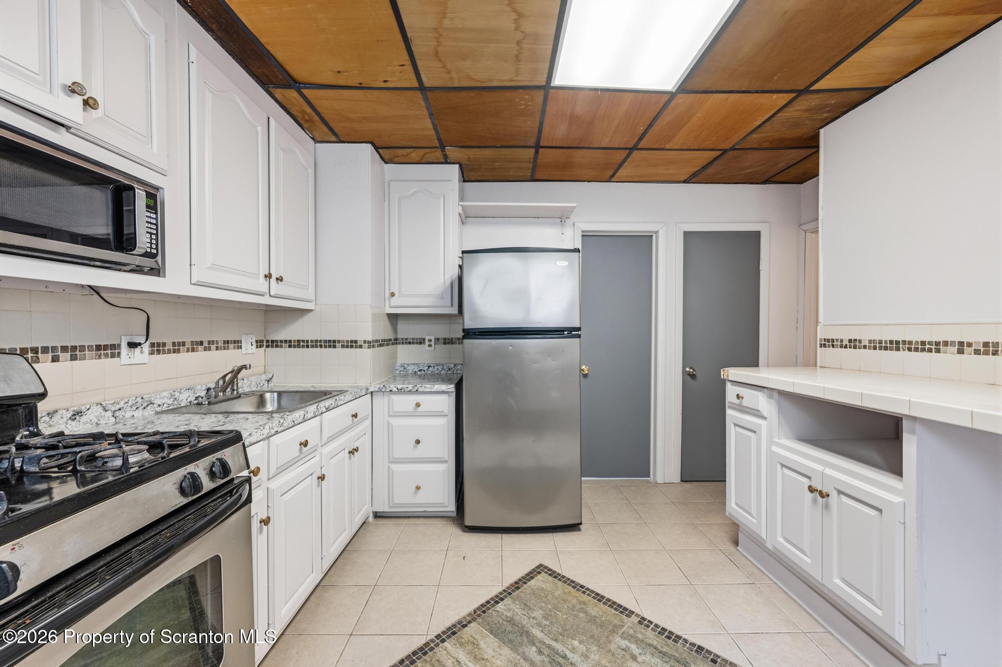 1413 Bulwer Street Scranton, PA 18504 - Photo 6 of 45 a kitchen with stainless steel appliances granite countertop a stove and a refrigerator