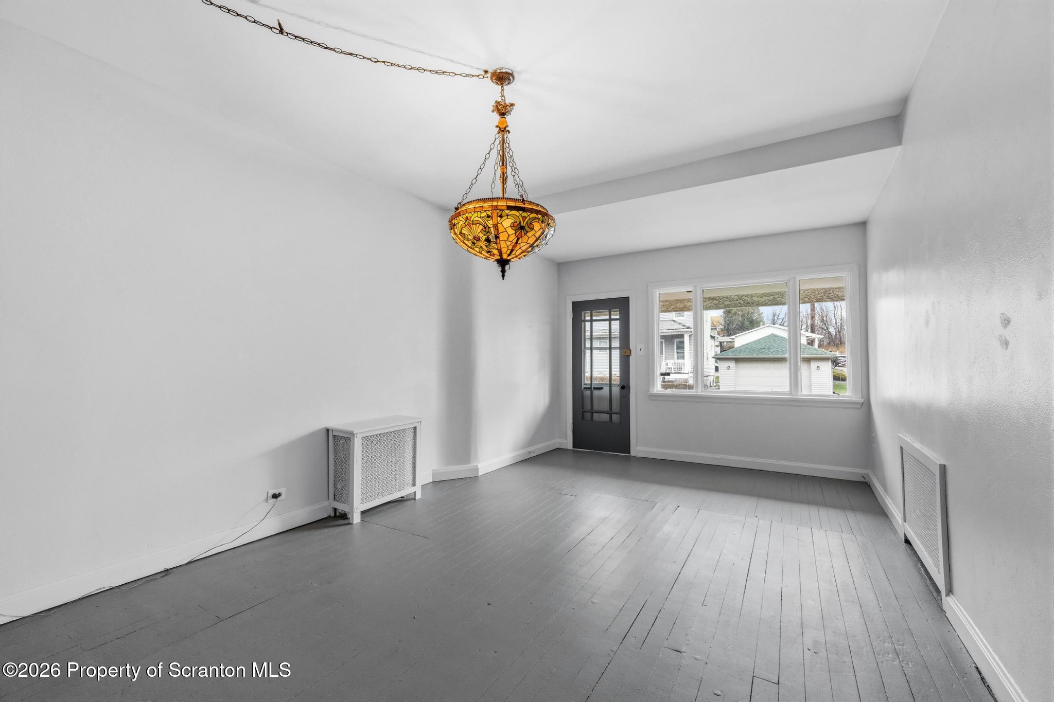 1413 Bulwer Street Scranton, PA 18504 - Photo 8 of 45 a view of an empty room with a window and wooden floor