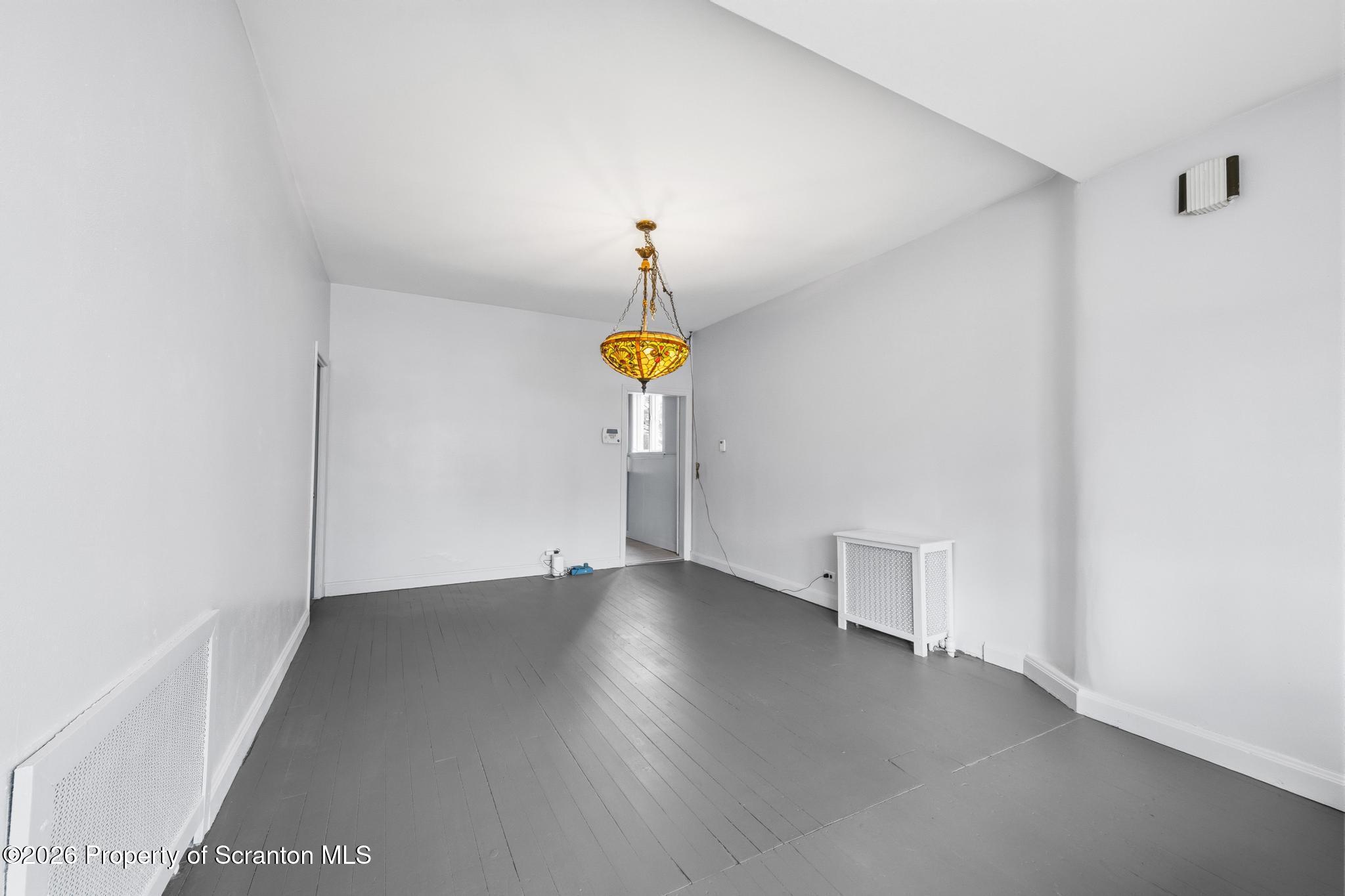 1413 Bulwer Street Scranton, PA 18504 - Photo 10 of 45 a view of an empty room with wooden floor and a window
