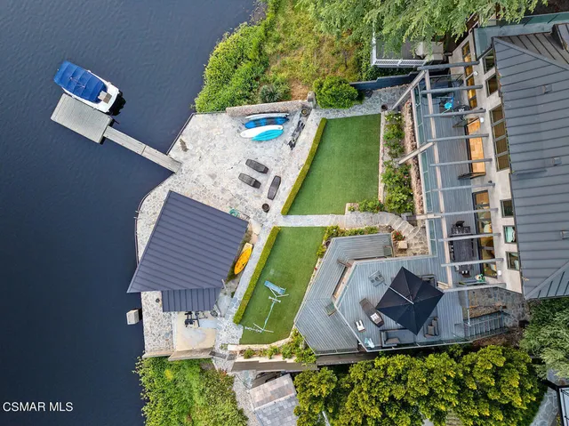 a view of a city from a patio with couches table and chairs and potted plants