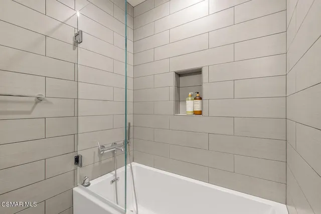 a kitchen with stainless steel appliances granite countertop a dining table chairs stove and white cabinets