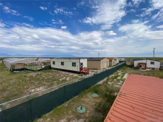 a view of a big house with a big yard and large trees