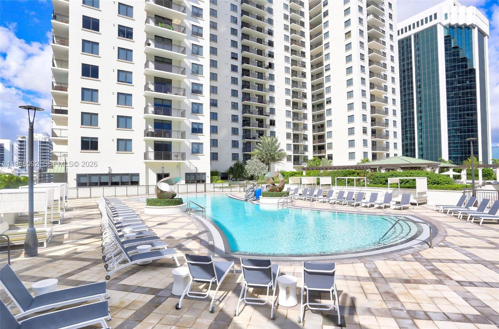 999 Southwest 1st Avenue, Unit 2310 Miami, FL 33130 - Photo 3 of 17 a view of a swimming pool with outdoor seating