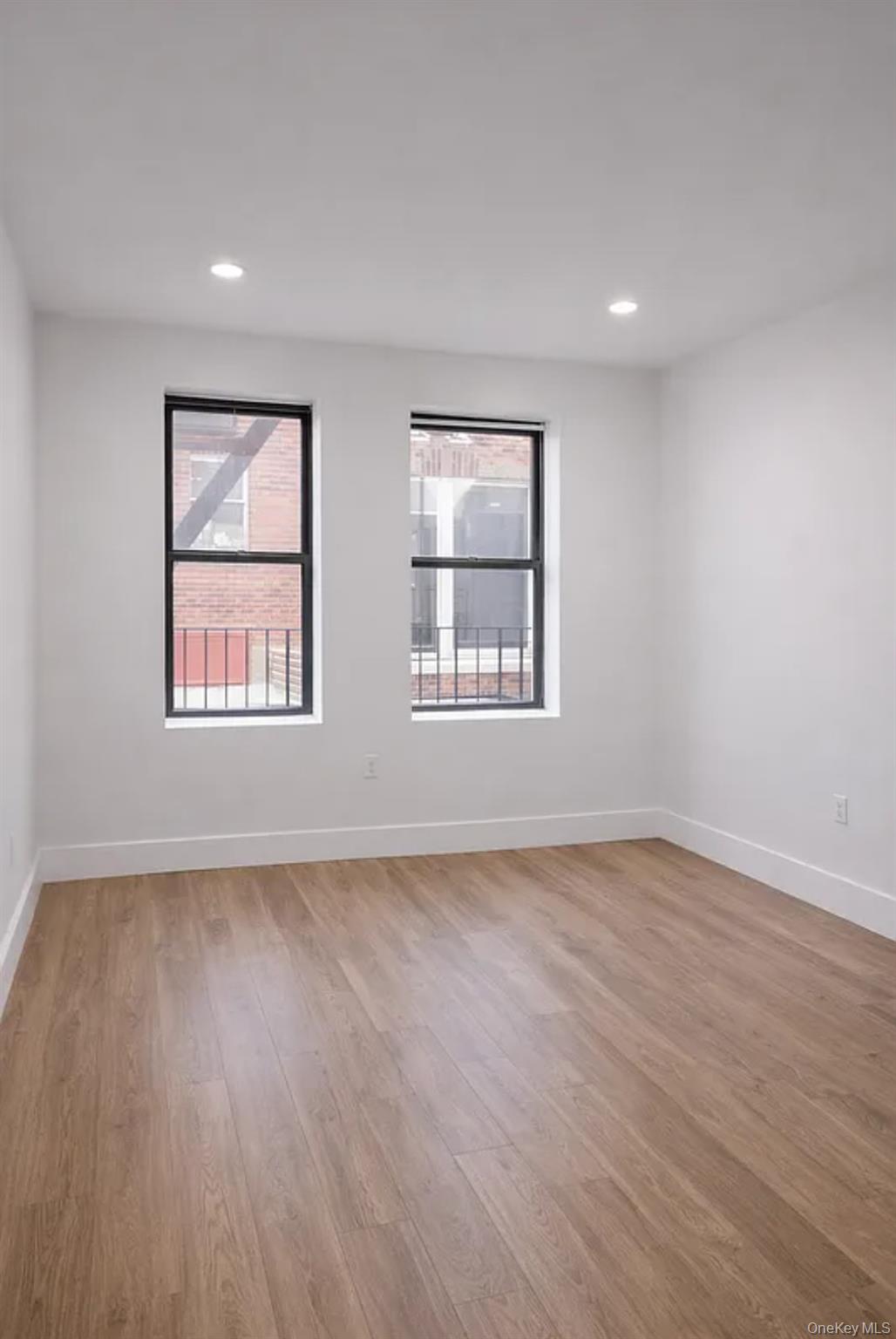 98-07 37th Avenue Queens, NY 11368 - Photo 2 of 5 a view of an empty room with wooden floor and a window