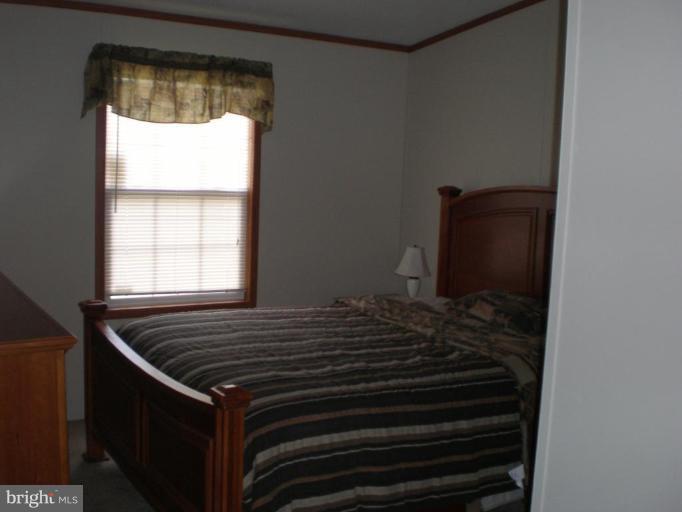 4744 Poplar Neck Road Preston, MD 21655 - Photo 7 of 11 a bed sitting in a bedroom next to a window