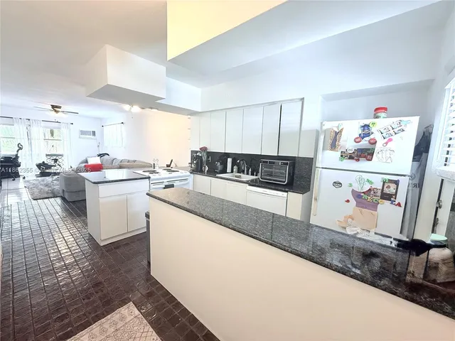 a kitchen with stainless steel appliances granite countertop a sink stove and white cabinets